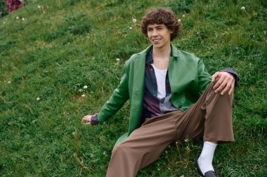 Yakışıklı genç bir öğrenci dışarıda dinleniyor, yürüyüşü sırasında doğanın huzur veren güzelliğine dalmış..