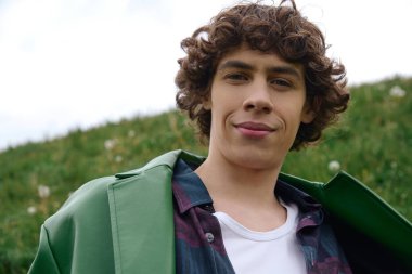 Yakışıklı bir öğrenci yeşil alanlarda geziniyor, neşe ve gençlik saçıyor..