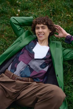 Genç öğrenci yeşil alanda yürüyor, şık bir elbiseyle neşe ve güven saçıyor..