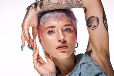 Yaratıcı bir stüdyoda renkli kısa saçlar ve benzersiz dövmeler sergileyen genç bir kadın..