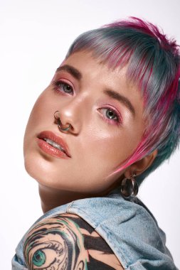 Canlı, kısa boyalı saçlı genç bir kadın şık bir stüdyoda güzelliğini sergiliyor..