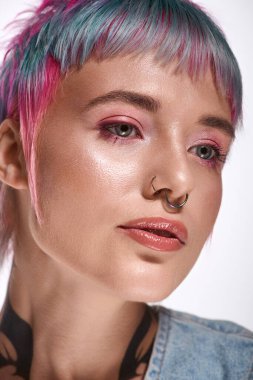 Genç bir kadın, canlı ve kısa saçlarını stüdyo ortamında güzelliğini gösterirken sergiliyor..