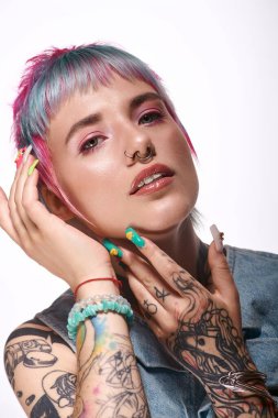 Stüdyoda, canlı boyalı saçları olan genç bir kadın güzellik ve sanatla tarzını ifade eder..