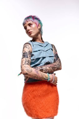 Renkli saçlı genç bir kadın, kendine güvenerek kendine özgü moda anlayışını sergiliyor..