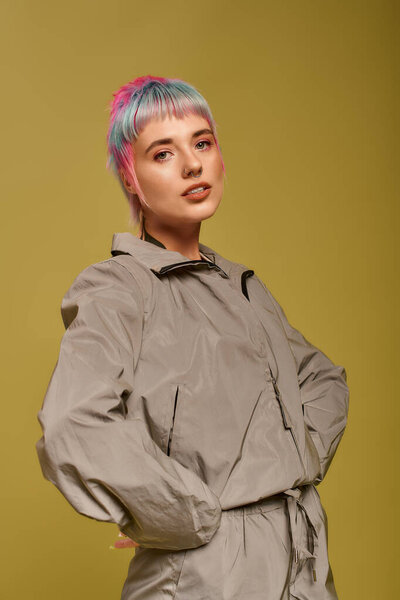 A young woman showcases her short, vibrant hair while posing confidently in a studio.