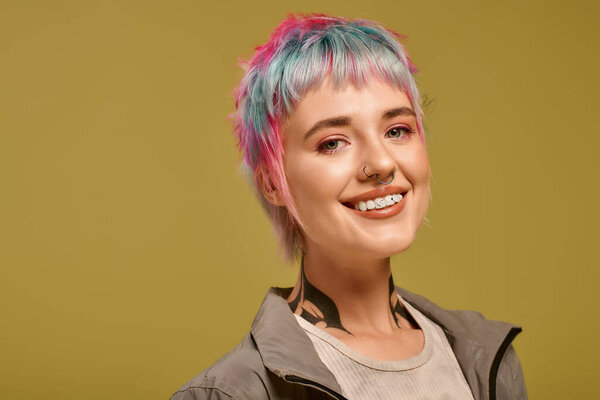 A young woman with short colorful hair expresses her style in a lively studio.