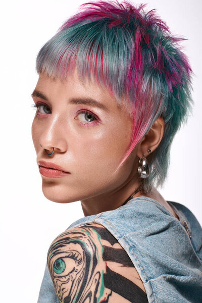 A young woman with bright short hair poses confidently in a vibrant studio.