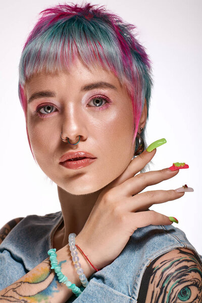 A young woman showcases her colorful short hair and striking fashion while posing in a studio.