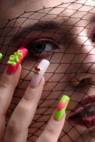 A young woman with colorful short hair showcases her unique beauty in an artistic studio.