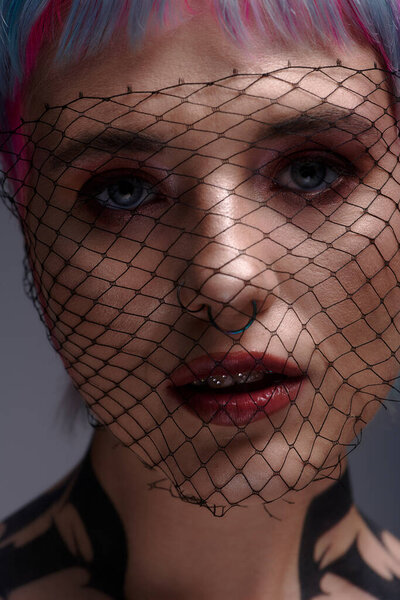 A young woman showcases her colorful hair and unique style in a creative studio setting.