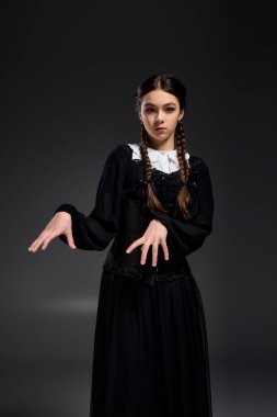 Gotik tarzda giyinmiş genç bir kız Cadılar Bayramı ruhunu yakalıyor, Çarşamba dansı yapıyor.