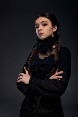 Bir kız, Cadılar Bayramı ruhunu somutlaştıran örgü ören gotik bir çarşamba elbisesi giyiyor..