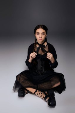 Çarşamba günü gotik giyinmiş bir kız sessizce oturur ve sonbahar Cadılar Bayramı atmosferini benimser..