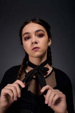 Ürkütücü çarşamba karakteri gibi giyinmiş bir kız örgü örgüleriyle Cadılar Bayramı 'nın özünü yakalıyor..