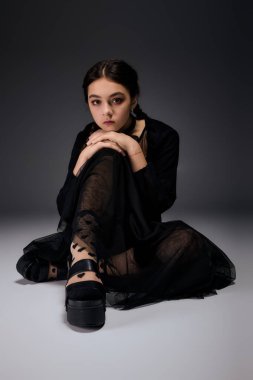 Saçları örülü bir kız koyu çarşamba elbisesi giyer, Cadılar Bayramı kutlamaları için mükemmeldir..