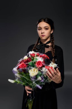 Çarşamba kostümlü kız elinde buket tutuyor, Ekim 'de ürkütücü sezonu kutluyor..