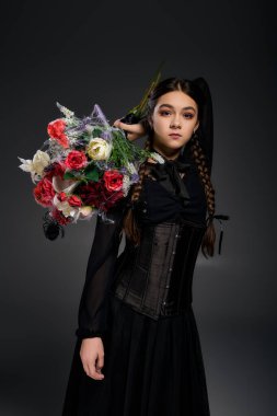 Çarşamba günü karakter kostümü giymiş bir kız Ekim ayında ürkütücü bir buket tutuyor..