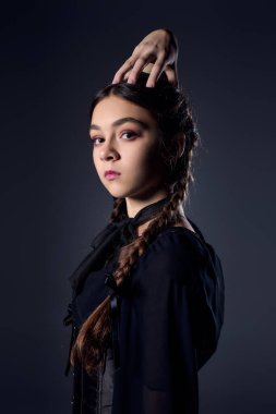 Örgülü bir kız, koyu gotik bir Çarşamba elbisesi içinde Cadılar Bayramı 'nın özünü yakalıyor..