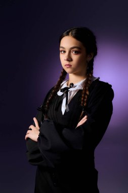 Örgü ören bir çocuk gotik bir Cadılar Bayramı elbisesi giyer, ürkütücü bir Çarşamba karakterini somutlaştırır..