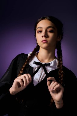 Örgülü bir kız, Çarşamba karakterinden gotik bir elbise giyer ve Cadılar Bayramı sonbahar ruhunu yakalar..