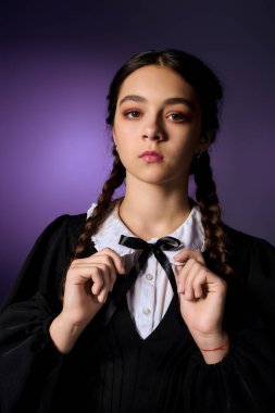 Örgü örgülü bir kız, Gotik bir Çarşamba elbisesi giymiş, Cadılar Bayramı ruhunu kucaklıyor..