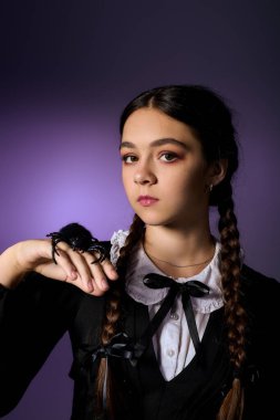 Gotik çarşamba karakterleri gibi giyinmiş çocuk, örgü örüyor, Cadılar Bayramı eğlencesi için örümceği sergiliyor..