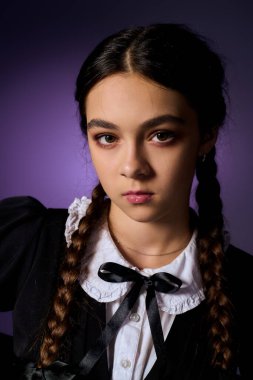 Örgülü genç kız gotik bir elbise giyer, ürkütücü sezonun ruhunu yakalar..