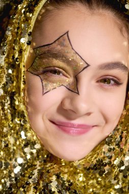 Yıldız tasarımlı bir kız altın pulların arasında parlıyor, Cadılar Bayramı 'nı kutluyor..