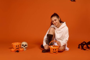 Samimi giyimli kız, şenlikli süslemeler ve ikramlar arasında ürkütücü sezonu kutluyor..