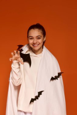 Kız neşeli bir şekilde Cadılar Bayramı 'nı ürkütücü süslemeler ve hoş bir gülümsemeyle kutluyor..