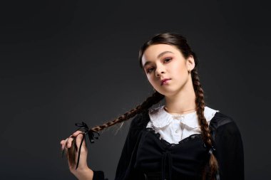 Örgülü bir kız, Çarşamba günü gotik bir elbise giyer ve Cadılar Bayramı 'nda giyeceği ürkütücü bir karakteri somutlaştırır..