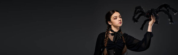 Girl in a gothic dress showcases her Halloween spirit with braids, embodying a Wednesday character, banner