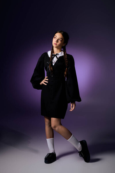 A girl with braids poses in a Wednesday dress, celebrating Halloween in a creative way.