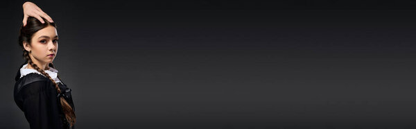 A girl with braids wears a gothic Wednesday dress to celebrate Halloween in style, banner