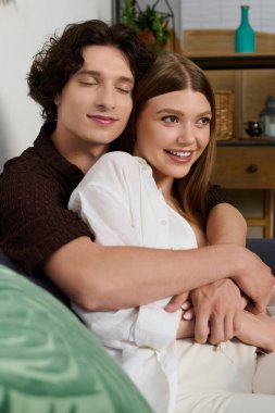 Young lovers share a joyful embrace in their modern home, radiating warmth and connection.