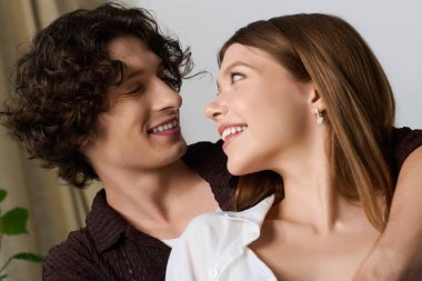 Young couple enjoys a joyful moment together in their stylish apartment, radiating love.