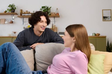 A cheerful young couple enjoys each others company in their modern living space.