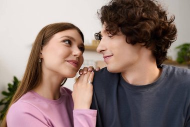 A joyful young couple enjoys each other's company in their stylish apartment, radiating love.