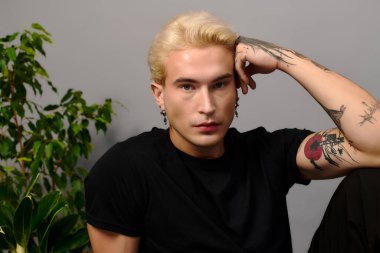 Genç adam eşsiz bir tarz ve tutum sergiliyor, gençlik kültürü ve moda eğilimleri sergiliyor..