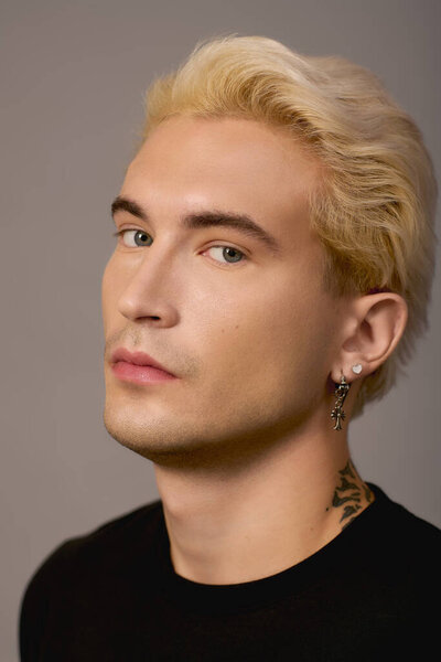 Молодой, стильный мужчина излучает уверенность и обаяние в современной обстановке.