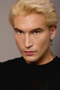 Sarışın ve çarpıcı görünümlü yakışıklı bir gencin moda ve kendine güveni var..