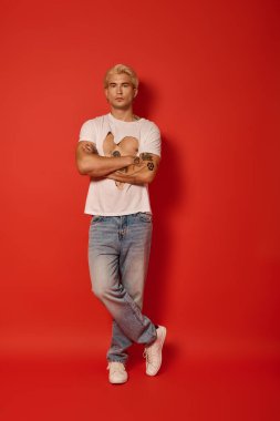 Modayı takip eden genç bir adam kollarını kavuşturmuş, çağdaş gençlik tarzını somutlaştırıyor..