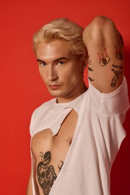 Şık genç, sanatsal bir ortamda modern eğilimleri vurgulayarak kendine güvenle poz veriyor.