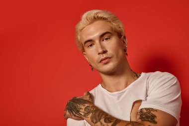 Gençler, gençlik kültürünü ön plana çıkaran koyu kırmızı bir zemine karşı dövmeler ve eşsiz bir stil sergiliyor..