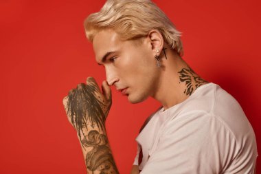 Genç, zarif dövmeleri ve çarpıcı saç stiliyle özenle poz veriyor..