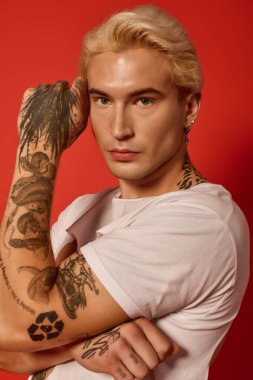 Çarpıcı dövmeleri ve sarı saçları olan yakışıklı bir genç cesur bir şekilde bireyselliğini ifade ediyor.