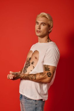 Modayı takip eden bir genç, genç enerjisini sanatsal dövmelerle harmanlayarak şık bir kıyafet sergiliyor..