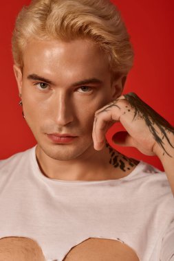 Yakışıklı genç bir adam modern moda, bireysellik ve çarpıcı bir ifade sergiliyor..