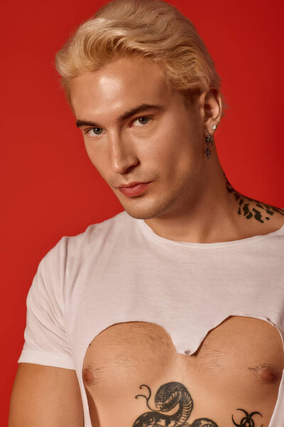 A handsome teenager showcases unique fashion and charisma against a bold red background.