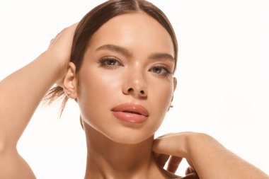 A beautiful young woman showcases her natural makeup against a pure white backdrop.